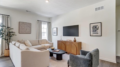 furnished great room with sectional, chair, credenza and tv