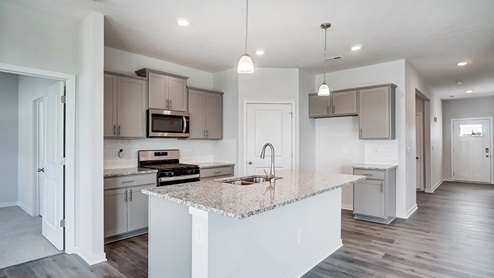 kitchen with grey cabinets, built in island, stainless steel appliances, walk in pantry