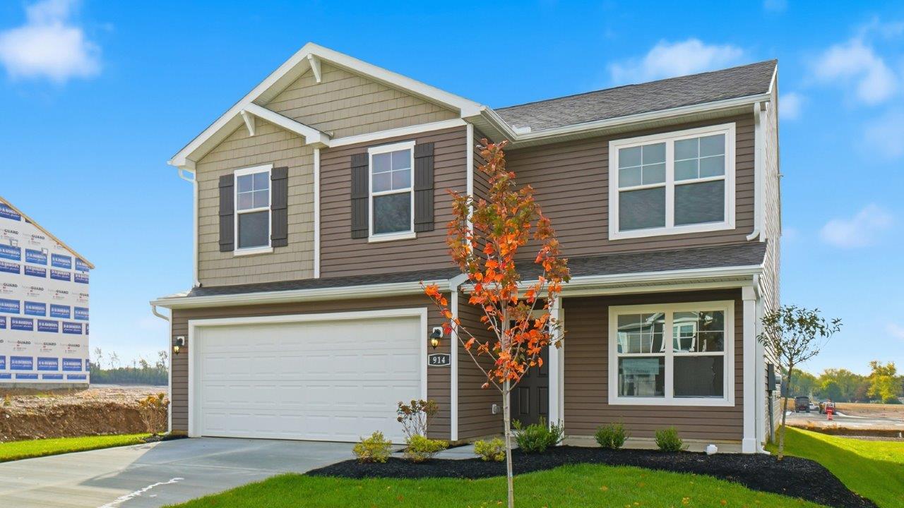 two story home with brown siding, covered front porch and two car garage