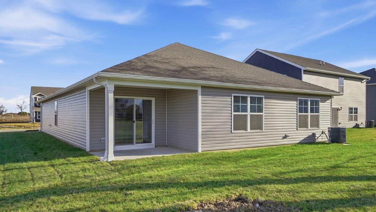single story home with grey siding rear exterior with covered patio