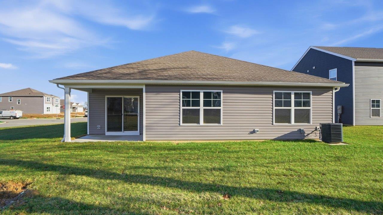 single story home with grey siding rear exterior with covered patio