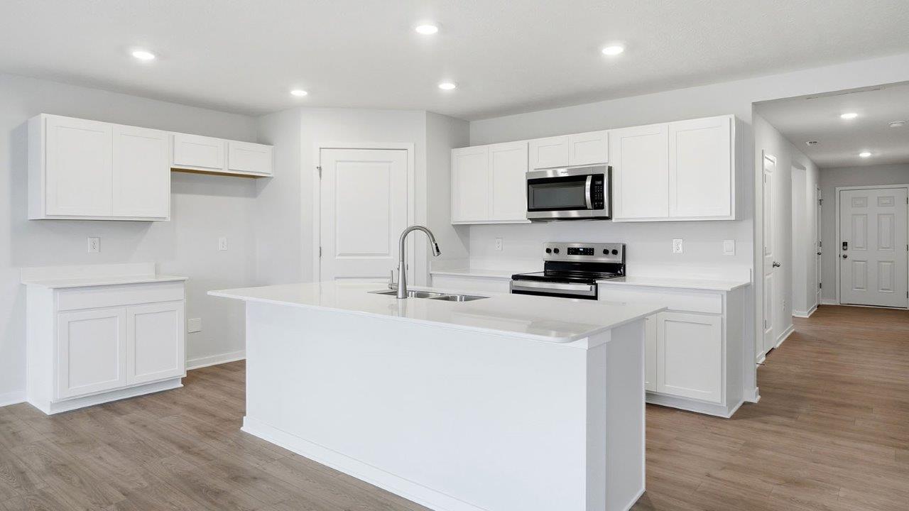 kitchen with white cabinets, built in island and corner walk in pantry