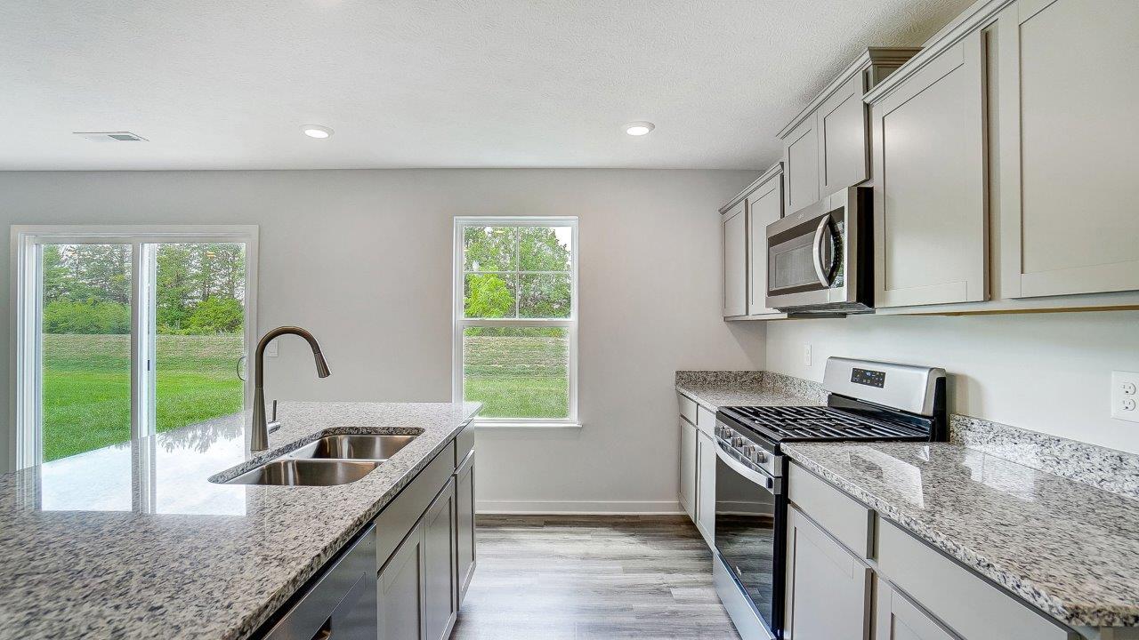 grey cabinets, hard surface counters, stainless appliances, single window