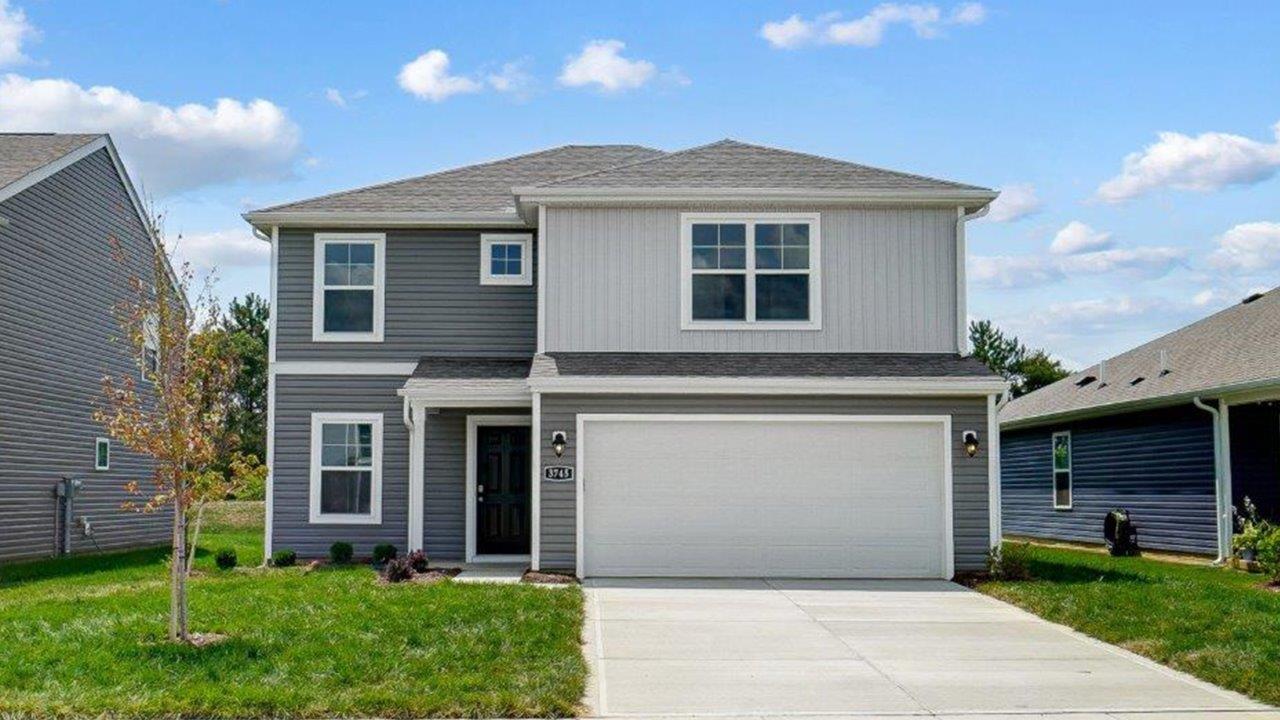 two story home with grey siding, covered entry, two car garage
