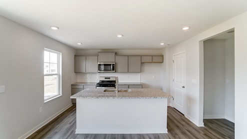 kitchen with built in island, grey cabinets, single window, walk in pantry