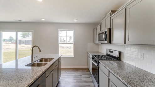 kitchen island, grey cabinets, stainless appliances, single window