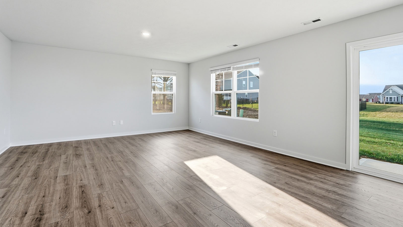 great room with two windows and rear sliding door