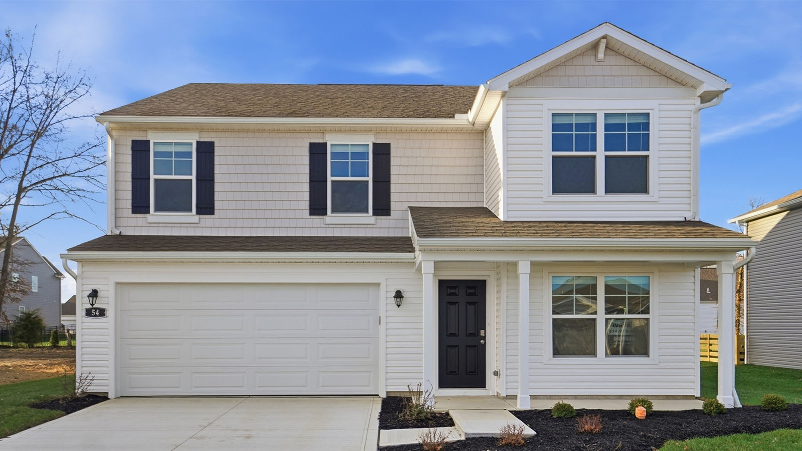 two story home with grey siding, black shutters, covered front porch and two car garage