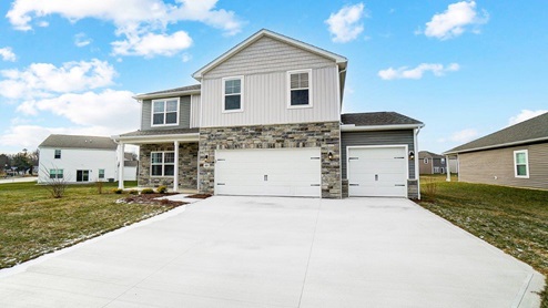 two story home with grey siding, partial stone front, covered front porch and three car garage