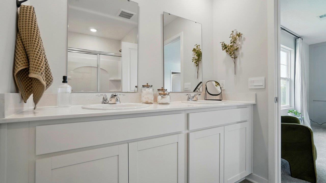 bathroom featuring dual vanity sinks with mirrors above