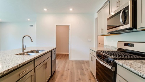built in island, grey cabinets, stainless appliances, laundry room