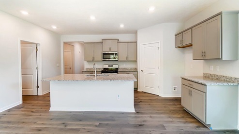 kitchen with grey cabinets, built in island, corner pantry, stainless steel appliances