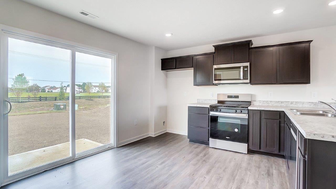 kitchen with brown cabinets, attached island, stainless steel appliances and rear sliding door