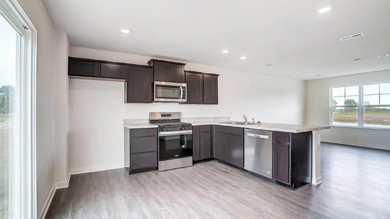 kitchen with brown cabinets, attached island and stainless steel appliances
