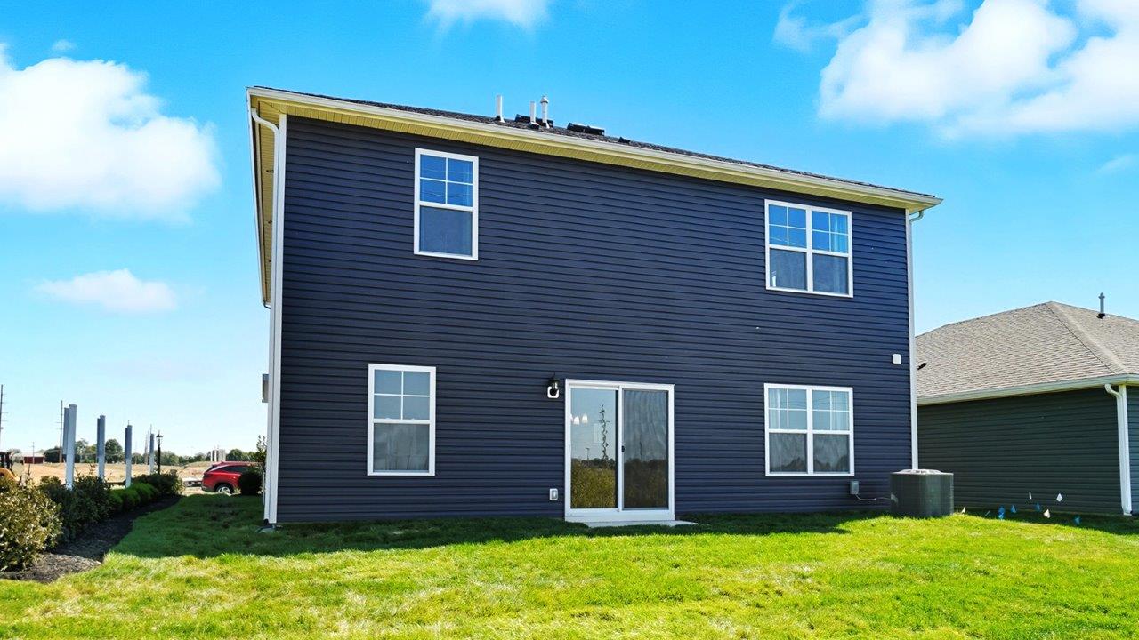 two story home with blue siding rear