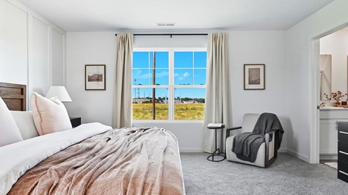 furnished primary bedroom with double window