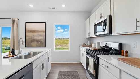 white cabinets, built in island, stainless steel appliances, single window