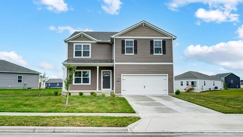 two story home with brown siding, covered entry, two car garage