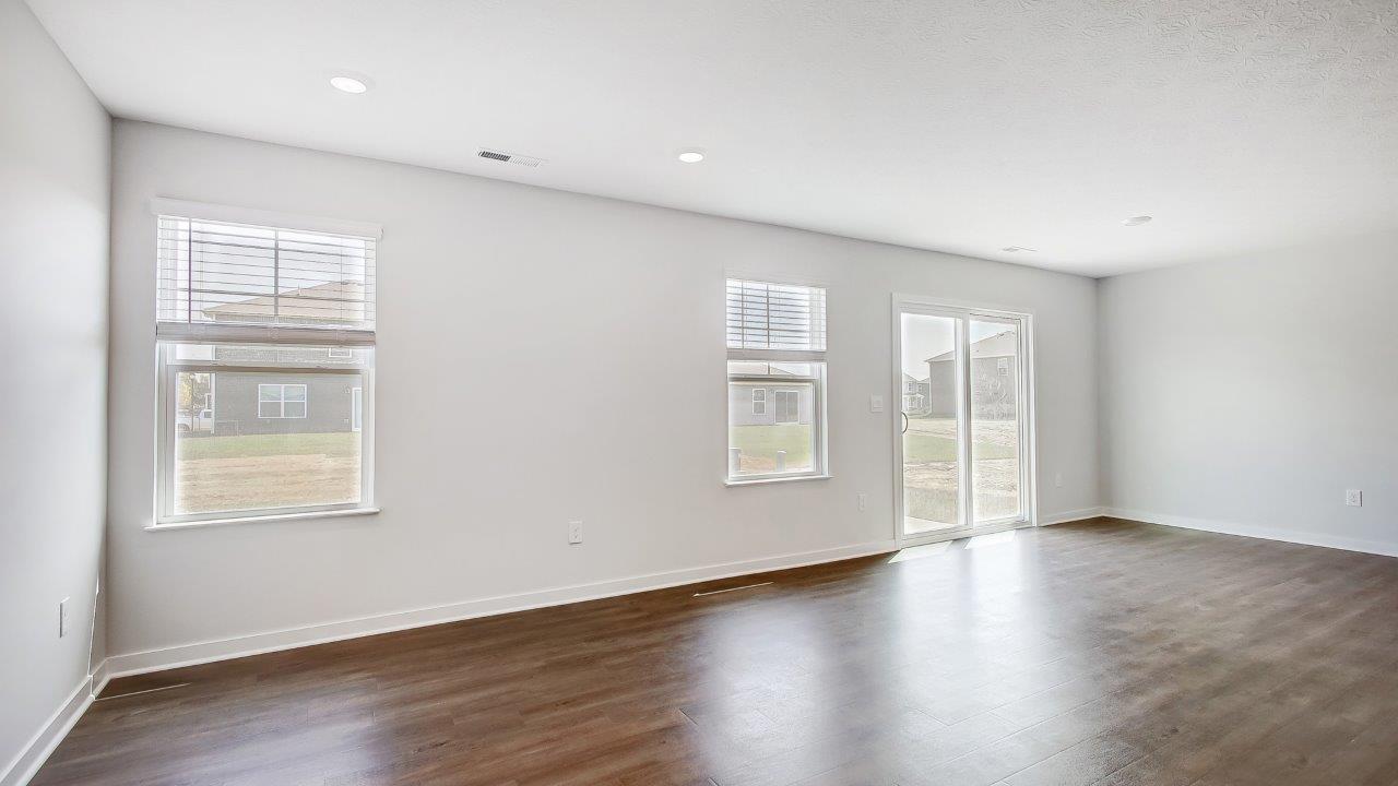 Living room looking into the back yard is near dining and kitchen areas in this new home features natural light, connectivity