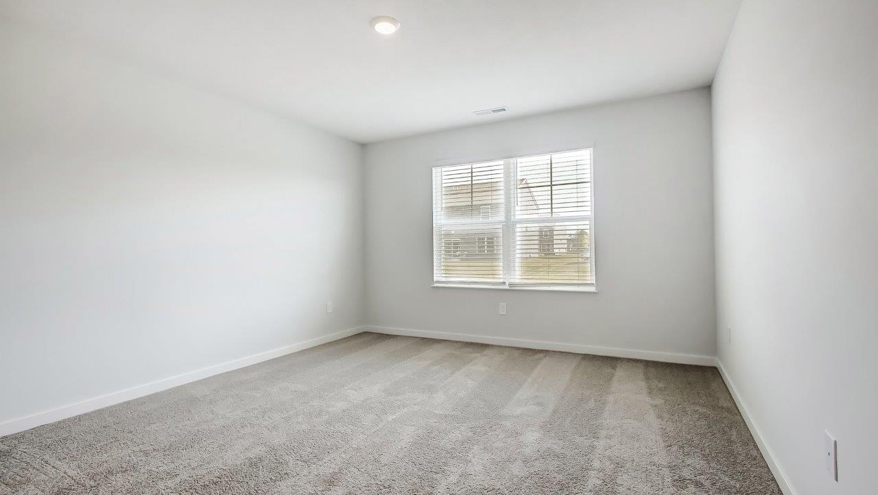 Primary bedroom features ample space, double windows, soft carpet, a stylish walk-in closet, and a private ensuite bath
