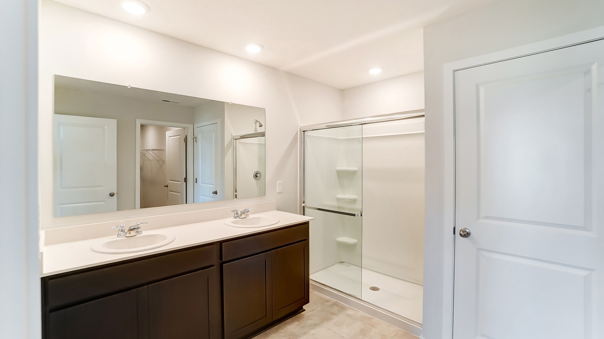 Primary bedroom features ample space, double windows, soft carpet, a stylish walk-in closet, and a private ensuite bath