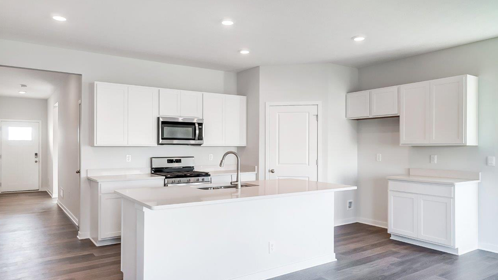 Central kitchen island anchors the home adding a dining option, full sink, pantry and storage, multi-prep zones