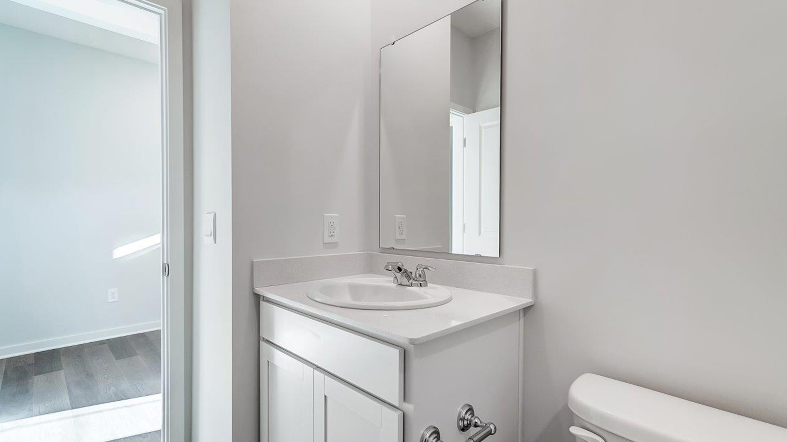 Family bathroom with stylish vanity, mirror, polished fixtures, cabinets, tub-shower combo in Lansdowne Farms