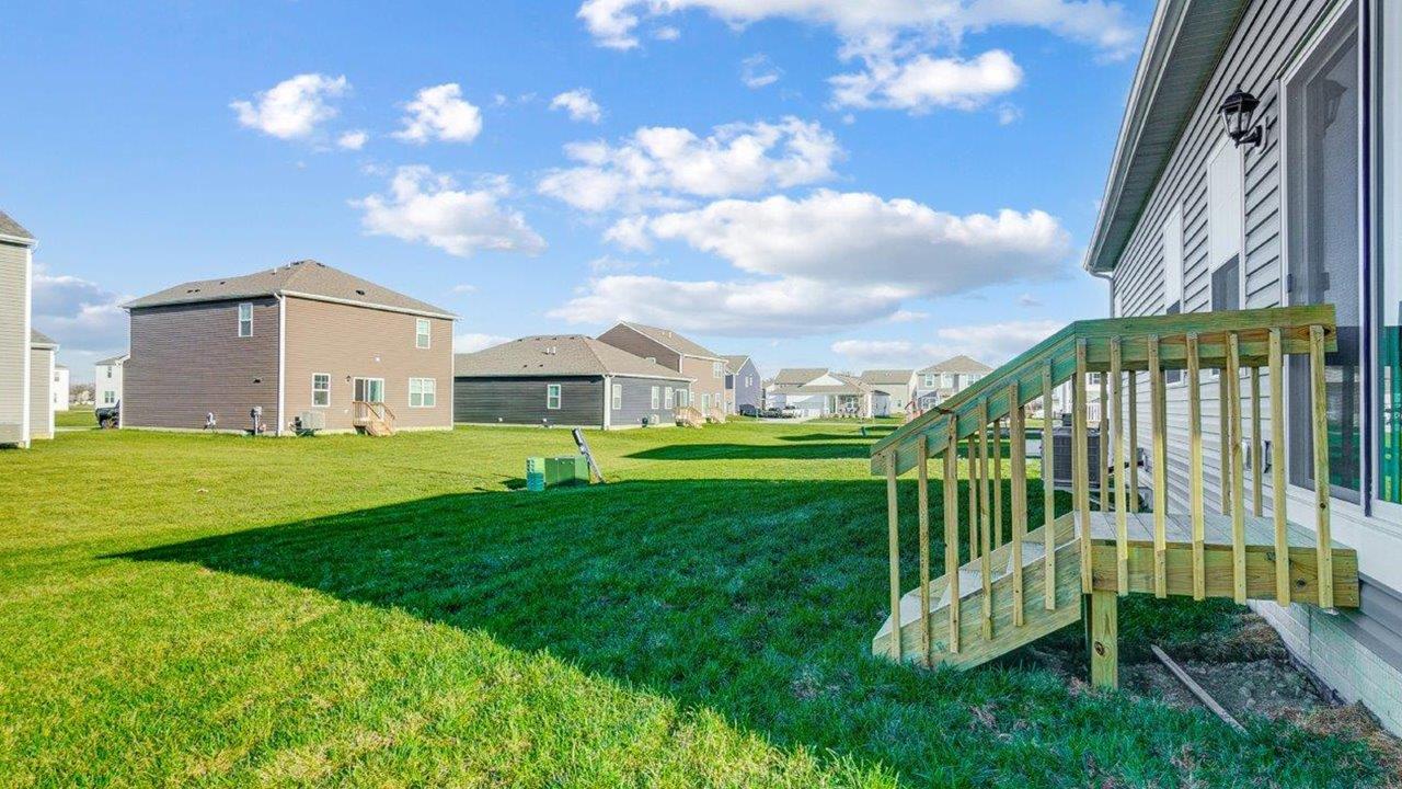 Backyard deck offering access for seating, grill setup, and a transition from indoor to outdoor living
