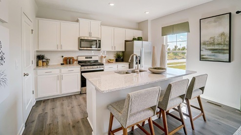 kitchen with white cabinets and island with barstools
