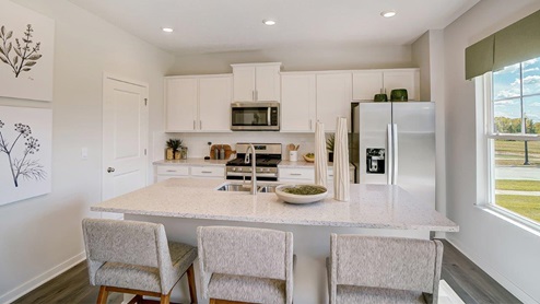 kitchen with white cabinets, walk in pantry and island