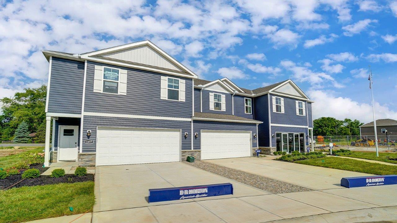 three unit, two story townhomes with blue siding and two car garage