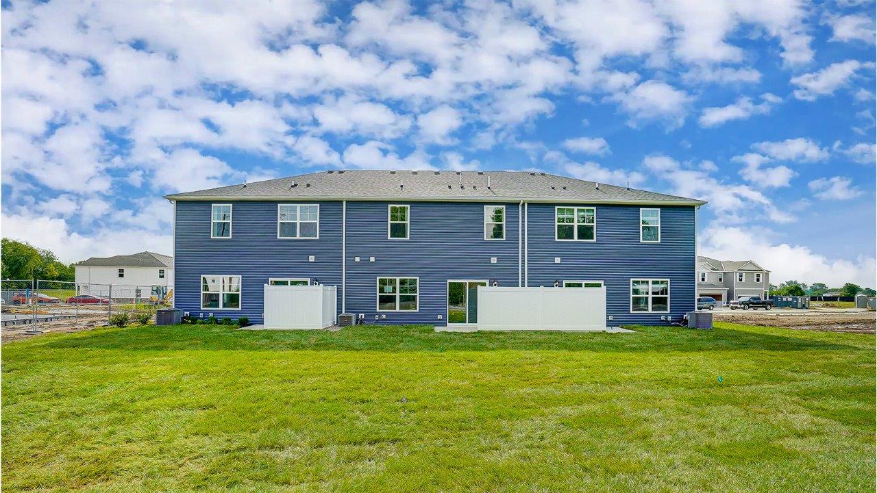 3 unit town home with blue siding and fenced patio