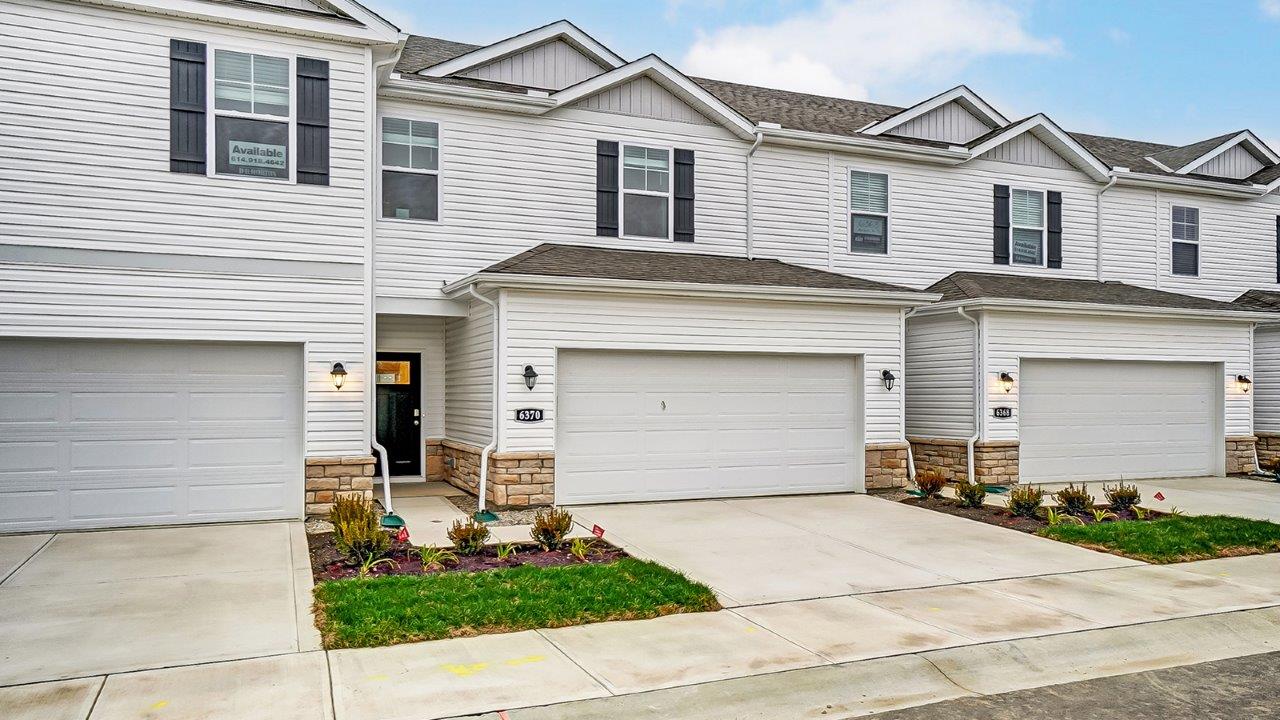 interior two story townhome until with white siding and two car garage