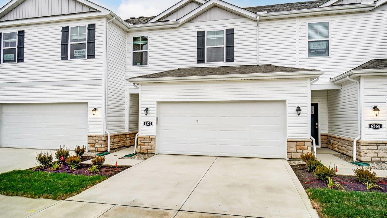interior two story townhome until with white siding and two car garage