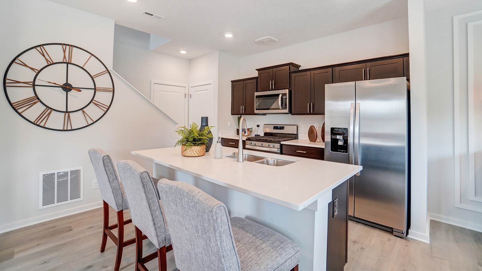 kitchen with brown cabinets, built in island with barstools, stainless steel appliances