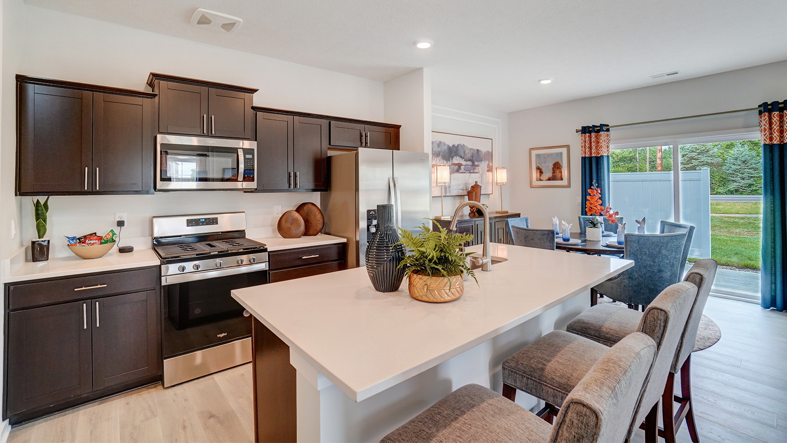 kitchen with brown cabinets, stainless steel appliances, built in island with barstools