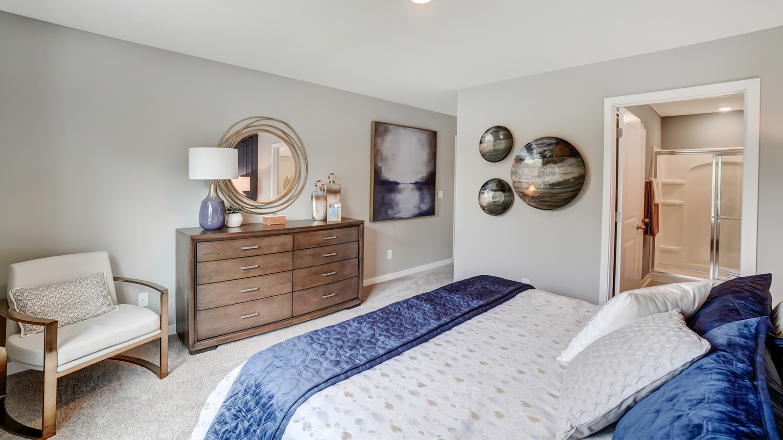 primary bedroom with queen bedroom, accent chair, dresser, ensuite bath