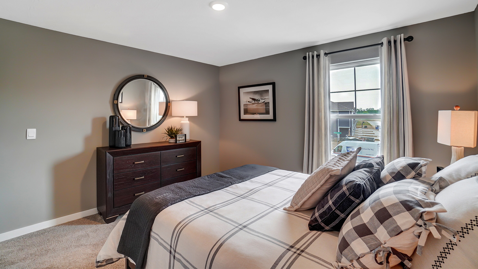 third bedroom with bed, dresser and mirror