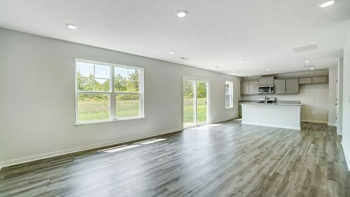 great room with double window, rear sliding door and kitchen