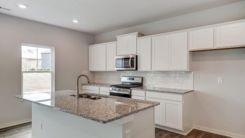 kitchen with white cabinets, built in island, stainless steel appliances, single window