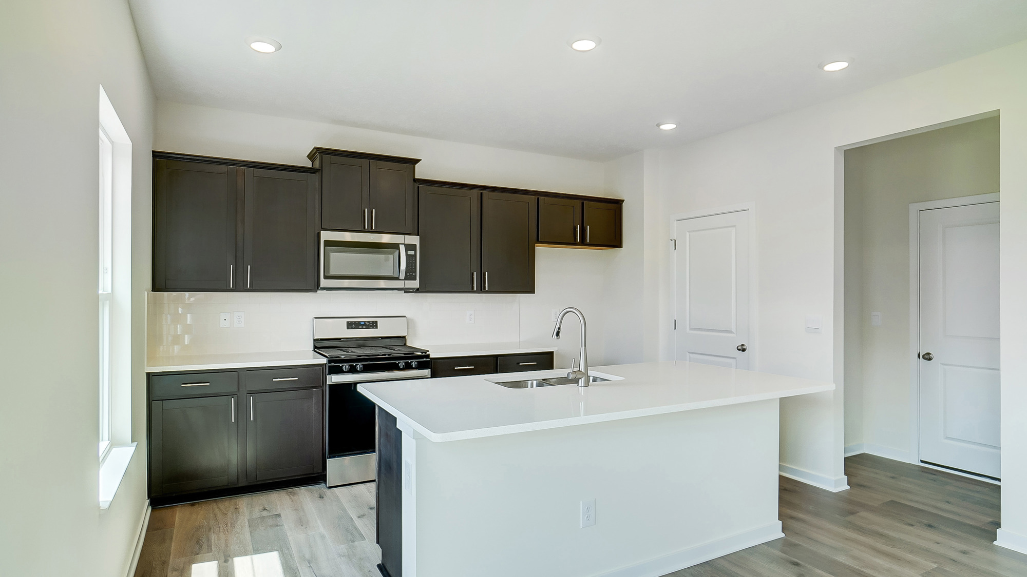 kitchen with brown cabinetry, large island and stainless steel appliances