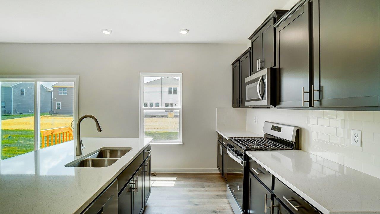 kitchen with brown cabinetry, large island and stainless steel appliances