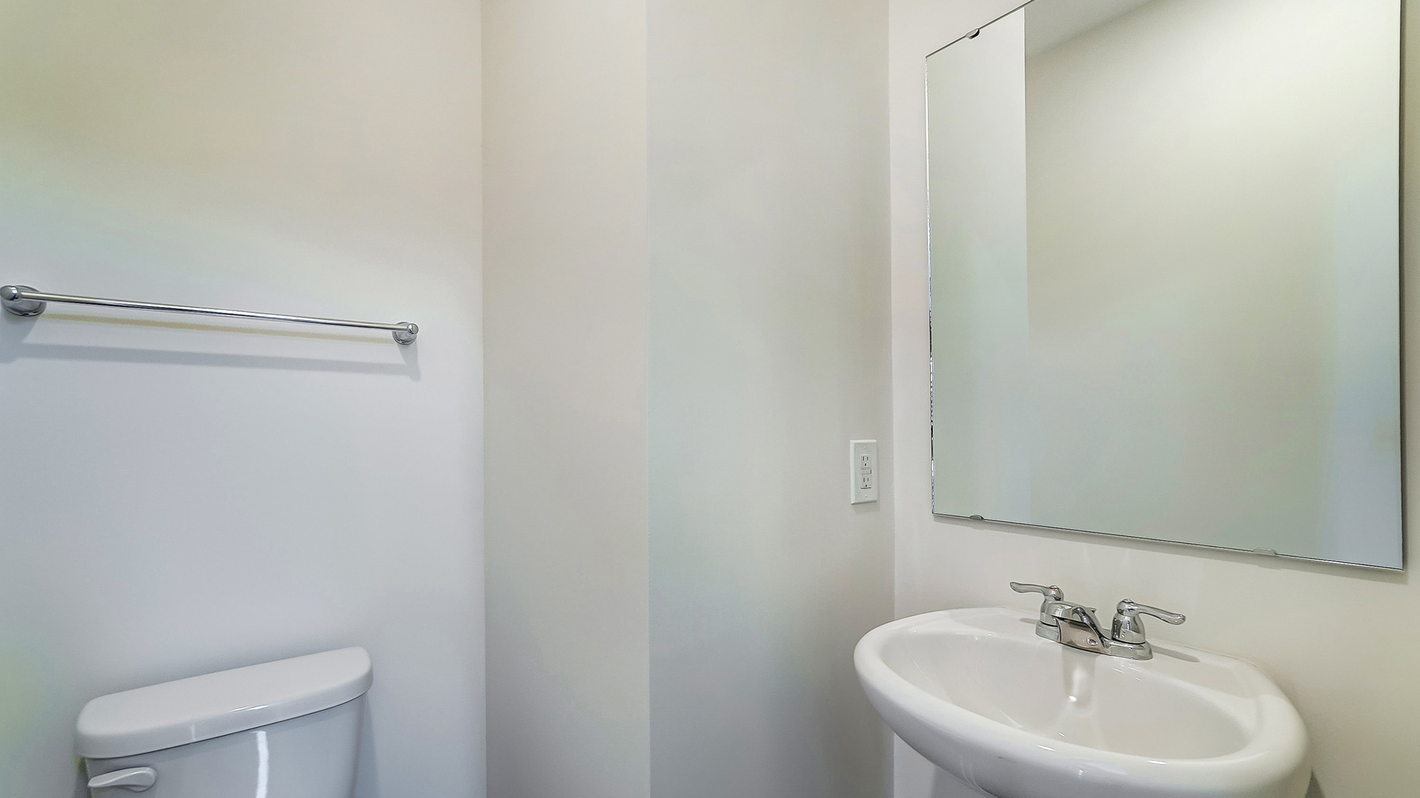 Powder bathroom with a pedestal sink and mirror