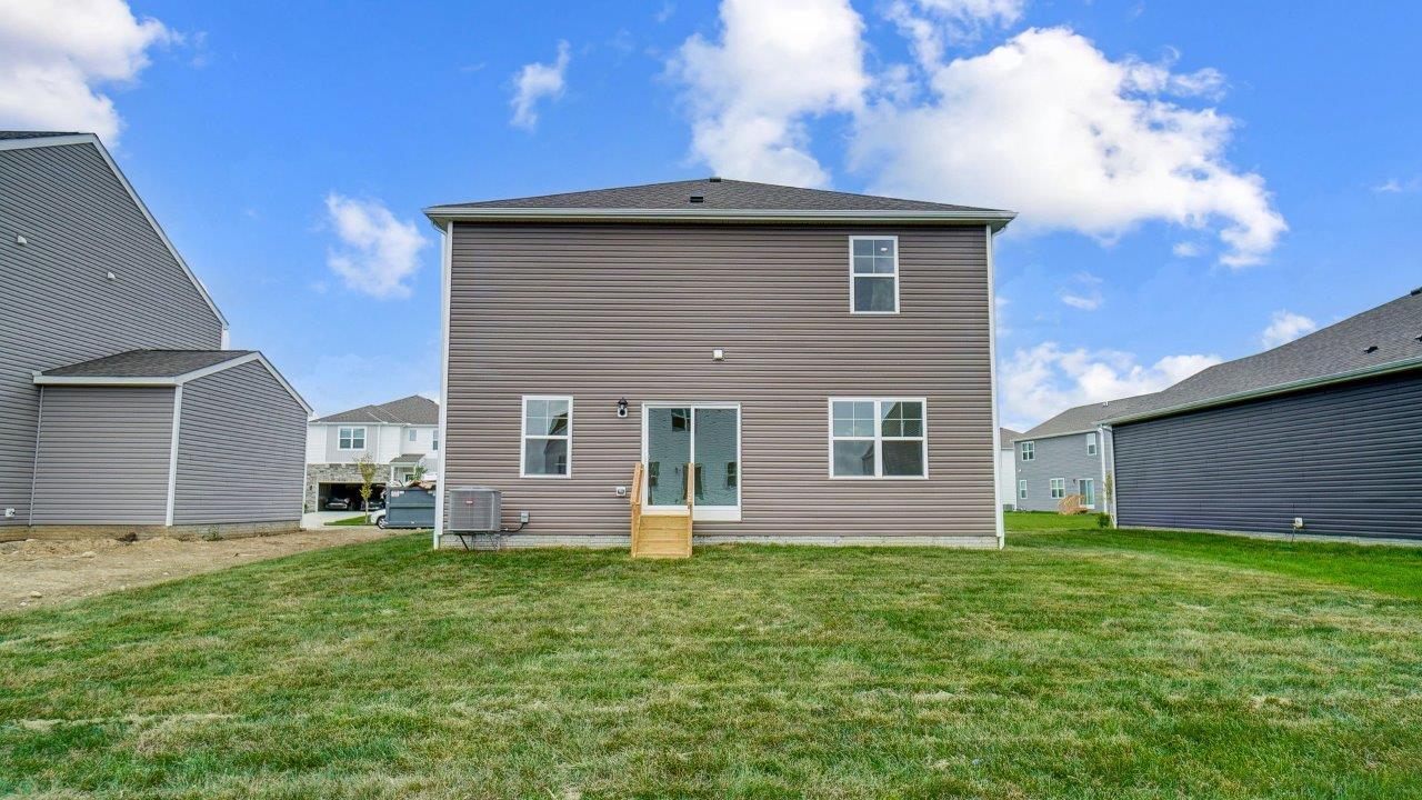 rear exterior of home featuring a spacious backyard