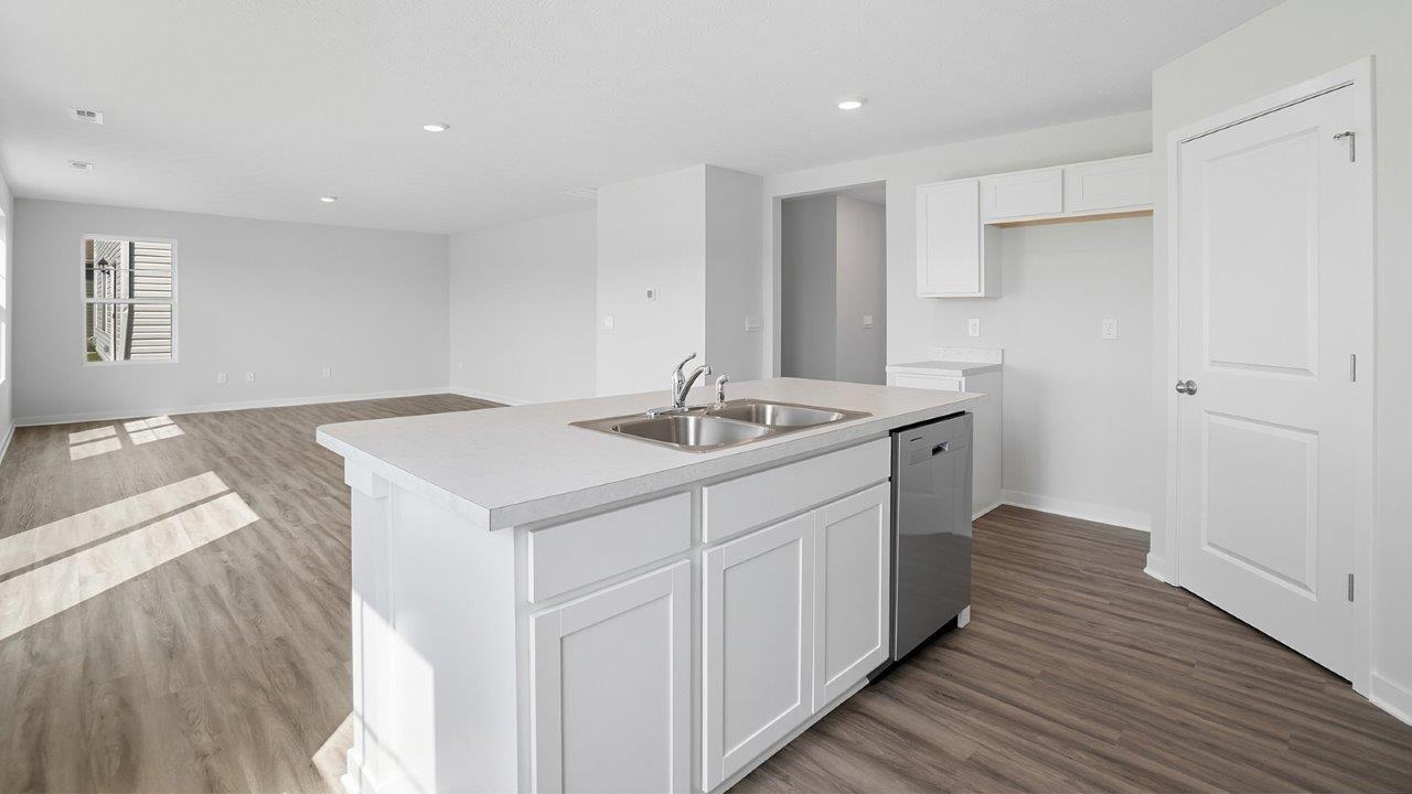 built in island with white cabinets, dish washer and built in sink