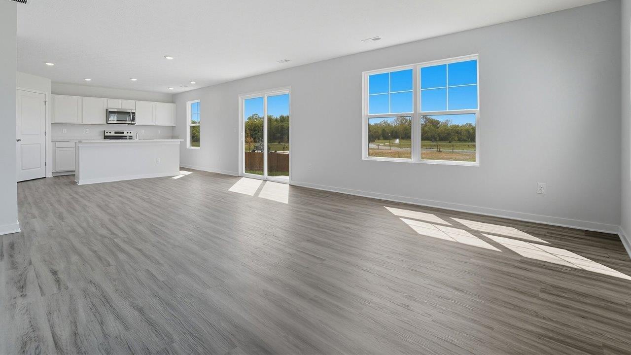 great room with double window, rear sliding door and kitchen