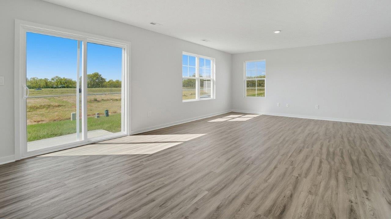 dining space with rear sliding door, great room with two windows