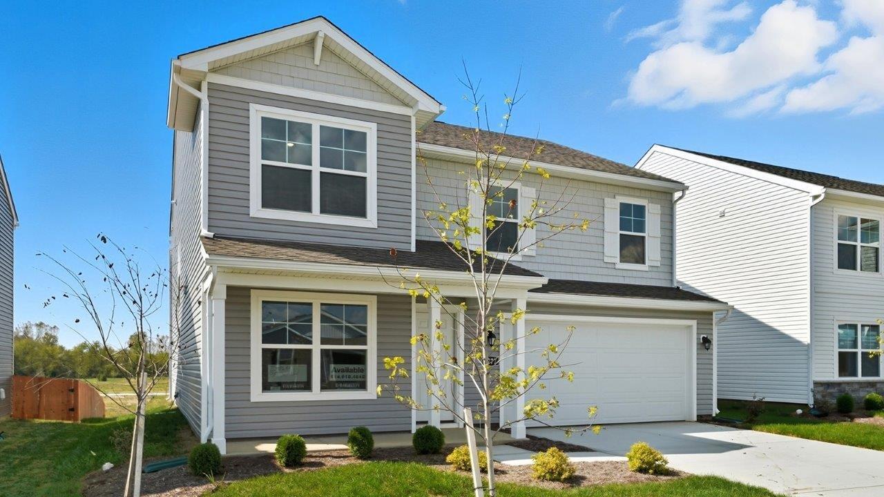 two story home with grey siding, covered front porch and two car garage