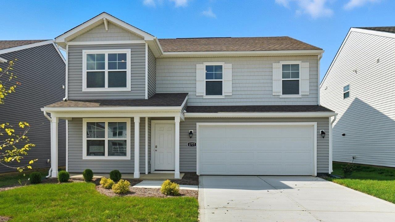 two story home with grey siding, covered front porch and two car garage