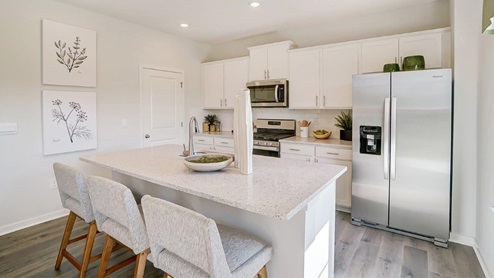 kitchen island, white cabinets and appliances